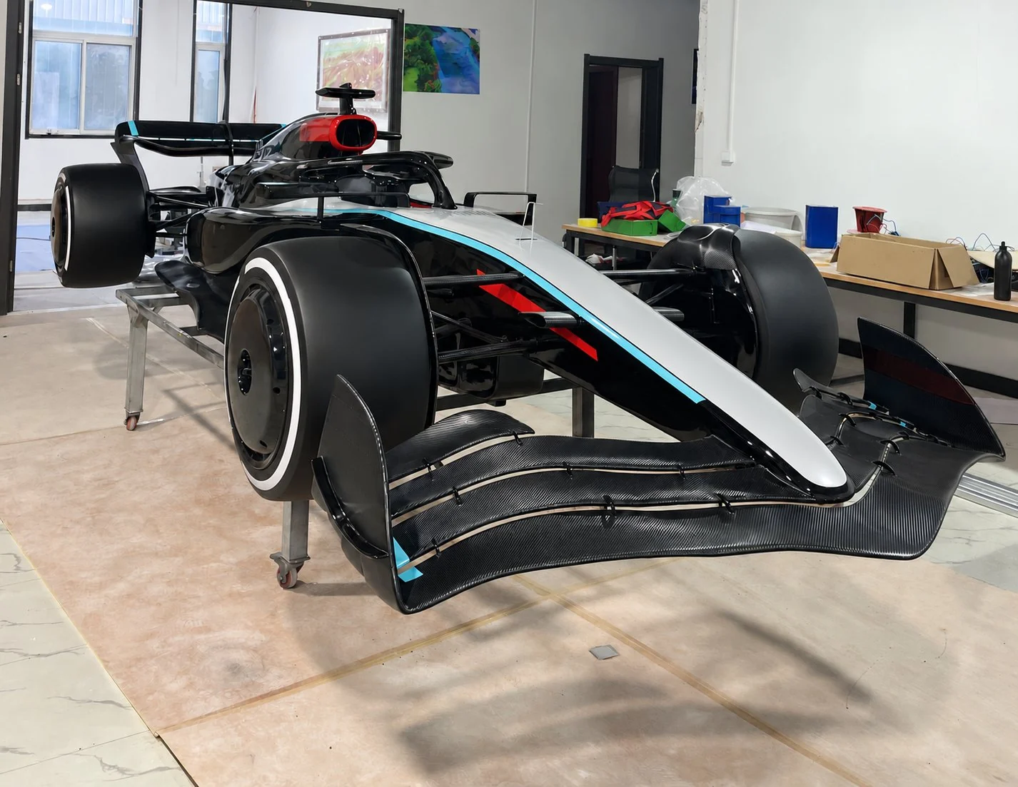 Formula-style show car in black and silver with turquoise accents, front view, graphics removed