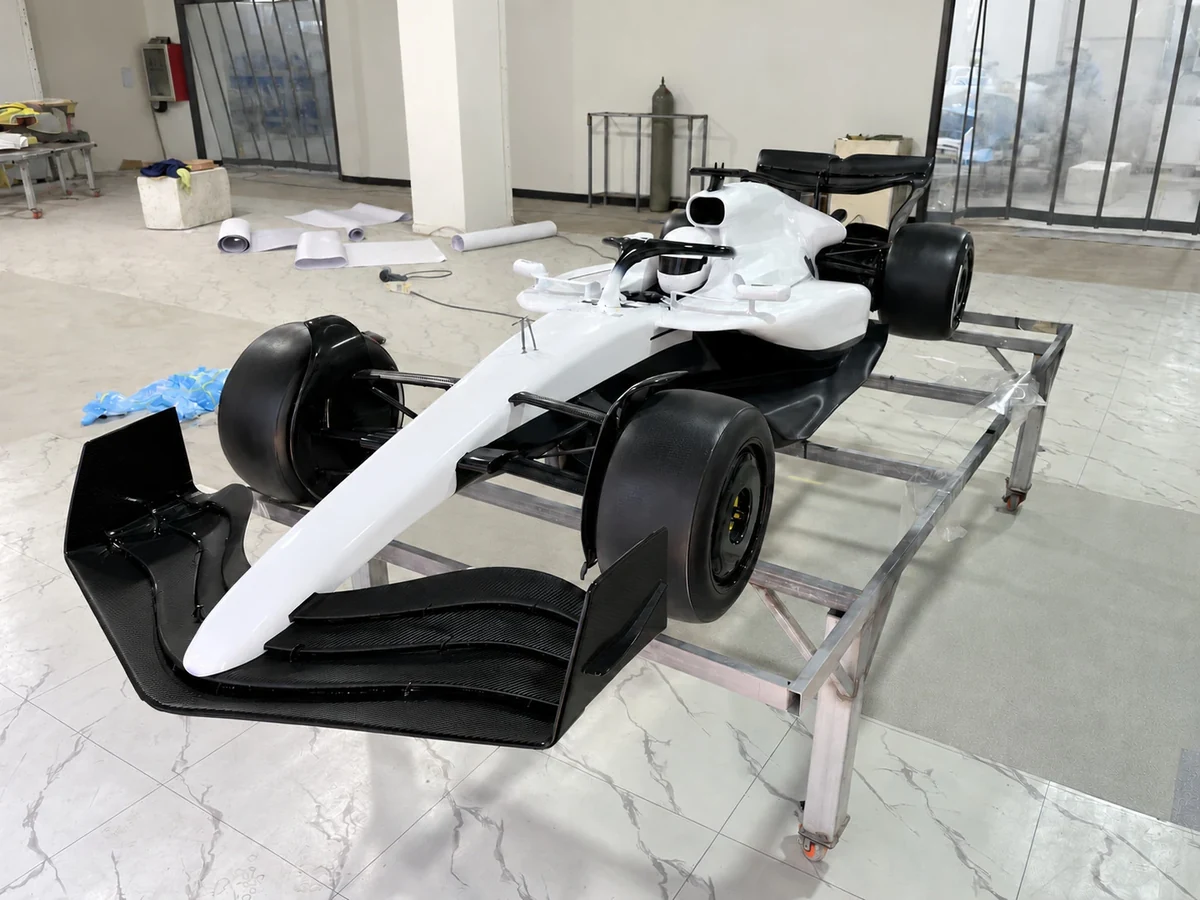 Formula-style show car in white and black, front three-quarter view, graphics removed
