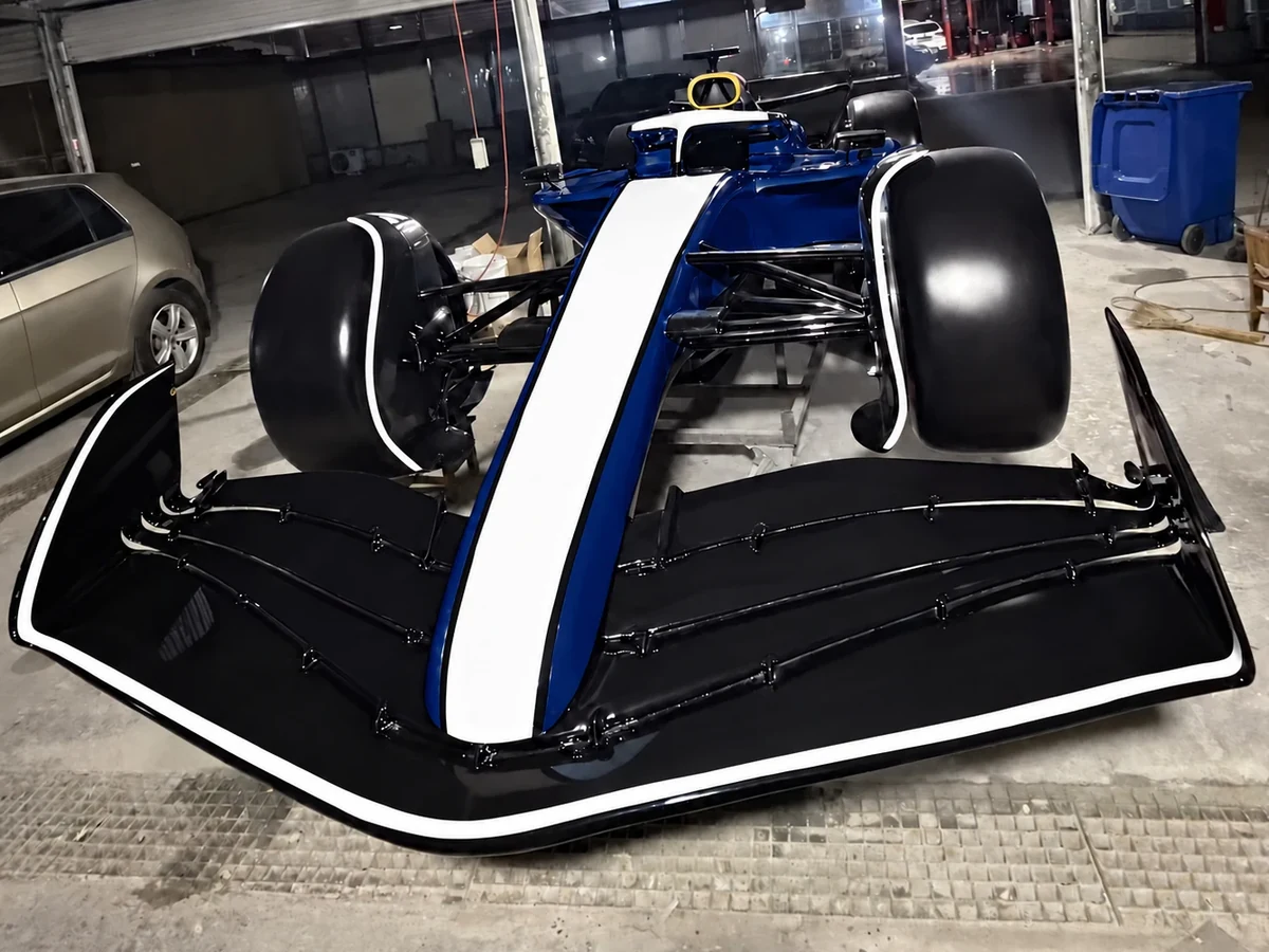 Formula-style show car in deep blue and white, front view, body graphics removed