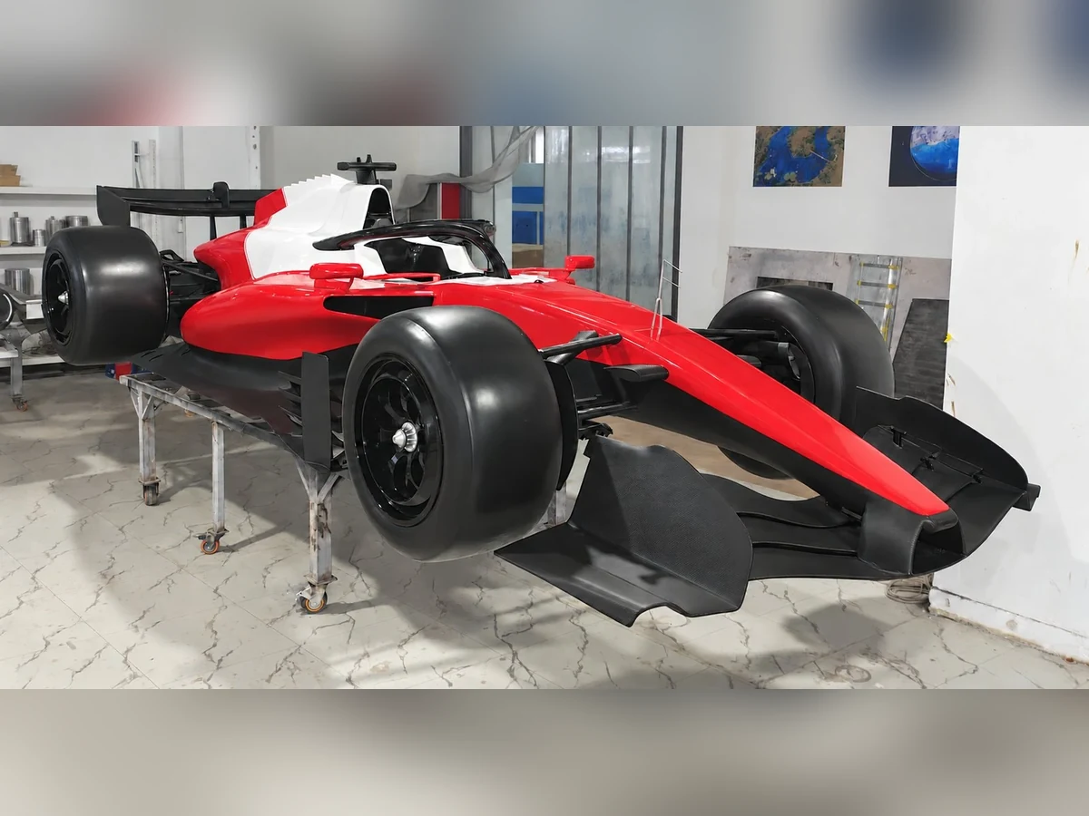 Full-size formula-style show car in red and white, front three-quarter view, graphics removed