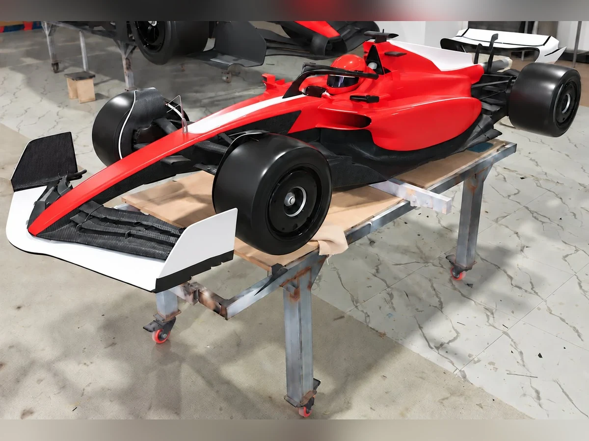 Half-scale formula-style show car in red and white, front three-quarter view, graphics removed